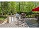 This outdoor kitchen features stainless steel appliances and stone counters, perfect for entertaining in a lush backyard at 6914 Riesman Ln # 95, Charlotte, NC 28210