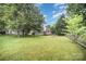 Well-maintained backyard featuring lush greenery and a charming split-rail fence at 7106 Kinsmore Ln, Charlotte, NC 28269