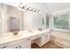 Spacious bathroom with a double vanity, bathtub, and windows to the backyard at 7106 Kinsmore Ln, Charlotte, NC 28269