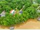 Aerial view of a home nestled amongst mature trees on a waterfront property with a dock at 8136 Energy Ln, Catawba, NC 28609