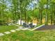 Beautiful backyard featuring a stone patio seating area, manicured lawn, and lush greenery, offering serene outdoor enjoyment at 8136 Energy Ln, Catawba, NC 28609