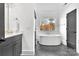 Contemporary bathroom featuring a soaking tub, dark cabinets, and herringbone floors at 8136 Energy Ln, Catawba, NC 28609