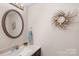 Bathroom featuring a dark vanity with a stylish round mirror and decorative wreath at 119 Mary Louise Ct, Fort Mill, SC 29715