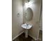 Compact bathroom with a pedestal sink, modern lighting, and neutral tones for a clean, functional space at 12120 Stratfield Place Cir, Pineville, NC 28134