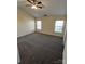 Spacious bedroom with plush carpeting, ceiling fan, and natural light from two windows at 12120 Stratfield Place Cir, Pineville, NC 28134
