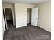 Neutral bedroom featuring soft carpet and a doorway leading to additional space at 12120 Stratfield Place Cir, Pineville, NC 28134