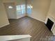 Corner view of a living room with fireplace, new flooring, and natural light from multiple windows at 12120 Stratfield Place Cir, Pineville, NC 28134