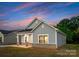 Angled view of a charming one-story home with gray siding, brick accents, and a cozy front porch at 1619 Martin Ave, Gastonia, NC 28052
