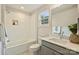 Bathroom featuring a tub with white subway tile surround, single sink vanity and modern fixtures at 205 Coxe Ave, Charlotte, NC 28208