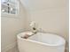 Bright bathroom highlighting a freestanding tub with wood caddy, faucet, and decorative plants at 205 Coxe Ave, Charlotte, NC 28208