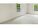 Empty bedroom showcasing a window and light carpet flooring at 205 Coxe Ave, Charlotte, NC 28208