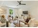 Bonus room features hardwood floors, a window, ceiling fan, and seating area with white couch and accent chairs at 205 Coxe Ave, Charlotte, NC 28208