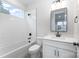 Bright bathroom featuring a shower-tub combo with modern fixtures and subway tile at 208 Mattoon St, Charlotte, NC 28216