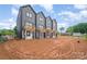 A wide view of the rear exteriors of modern townhomes, showcasing private balconies and ample space at 208 Mattoon St, Charlotte, NC 28216