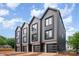 Modern townhome exteriors featuring gray siding, black trim, garages, and professionally landscaped front yards at 208 Mattoon St, Charlotte, NC 28216