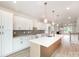 Bright kitchen featuring white cabinetry, a large island with quartz countertops, and stainless steel appliances at 208 Mattoon St, Charlotte, NC 28216