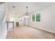 Open concept living room and kitchen with hardwood floors, white walls, and recessed lighting at 208 Mattoon St, Charlotte, NC 28216