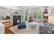 Bright living room featuring a fireplace, hardwood floors, and large windows overlooking the outdoor landscape at 208 Wendover Heights Cir, Charlotte, NC 28211