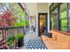 Inviting porch with comfortable seating, decorative plants, and stylish rug for outdoor relaxation at 208 Wendover Heights Cir, Charlotte, NC 28211