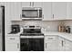 Modern kitchen with stainless steel appliances, white cabinets, and tiled backsplash at 2535 Andes Dr, Statesville, NC 28625