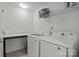 Bright laundry room featuring modern white appliances, countertop and shelving for storage at 2535 Andes Dr, Statesville, NC 28625
