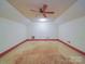 Attic space featuring a ceiling fan and neutral carpeting with red trim around the base of the walls at 2721 Tara Dr, Monroe, NC 28112