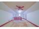 Expansive attic space with classic ceiling fan, trimmed in red with a small window and railing at 2721 Tara Dr, Monroe, NC 28112