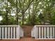 A verdant backyard view from the deck stairs, featuring lush greenery and a shed nestled among mature trees at 2721 Tara Dr, Monroe, NC 28112