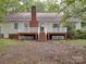 An inviting backyard featuring a spacious deck with white railing, brick foundation, and verdant foliage at 2721 Tara Dr, Monroe, NC 28112