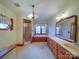 A large bathroom with wood cabinets, a bath tub, stand up shower and carpet flooring at 2721 Tara Dr, Monroe, NC 28112