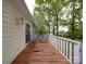 A weathered deck featuring white railing, peeling paint, and a sliding glass door entry to the home at 2721 Tara Dr, Monroe, NC 28112