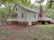 A charming single-Gathering home featuring a cozy side porch, brick foundation, and a classic brick chimney at 2721 Tara Dr, Monroe, NC 28112