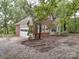 Brick home featuring an attached garage and back patio surrounded by gravel and mature trees at 2721 Tara Dr, Monroe, NC 28112