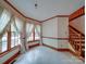 A well-lit living room with wood trim and staircase has big windows for natural light at 2721 Tara Dr, Monroe, NC 28112