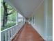 Inviting porch featuring a wooden floor, crisp white railing and views of the lush garden and trees at 2721 Tara Dr, Monroe, NC 28112