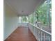 Covered porch featuring a wooden floor, white railing, and a peek at the backyard and surrounding trees at 2721 Tara Dr, Monroe, NC 28112