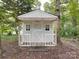 A quaint backyard shed with a welcoming porch, white trim, and windows, nestled amongst the trees at 2721 Tara Dr, Monroe, NC 28112