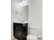 A well lit bathroom with a black cabinet, toilet, mirror and towel rack at 2835 24Th Street Ne Dr, Hickory, NC 28601