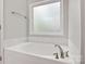 Bathroom featuring a large white tub with brushed nickel hardware and frosted window at 2835 24Th Street Ne Dr, Hickory, NC 28601
