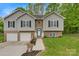 A charming split-level home featuring a manicured lawn, brick accents, a welcoming front door, and a two-car garage at 2835 24Th Street Ne Dr, Hickory, NC 28601