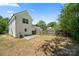 Back exterior view showcasing a lush backyard, with white siding and a concrete patio area at 3205 Morning Dr, Charlotte, NC 28208