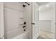 Clean white bathroom with a shower featuring black fixtures, next to a doorway at 3205 Morning Dr, Charlotte, NC 28208