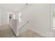 Hallway offers neutral tones, carpeting, and an access point to the stairs at 3205 Morning Dr, Charlotte, NC 28208