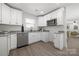 Modern white kitchen with stainless steel appliances and light granite countertops at 3205 Morning Dr, Charlotte, NC 28208