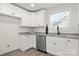 Well-lit kitchen featuring stainless steel appliances, white cabinets, and modern granite countertops at 3205 Morning Dr, Charlotte, NC 28208