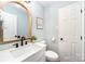 Bathroom featuring a white vanity with a black faucet and an arched mirror at 328 Earl Griffin Rd, Monroe, NC 28112