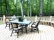 Relaxing outdoor deck featuring a dining table and seating, surrounded by lush greenery at 328 Earl Griffin Rd, Monroe, NC 28112