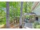 A terraced backyard leading to a covered deck space and a wooden deck overlooking the serene wooded backyard at 3329 Winnipeg Cir, Charlotte, NC 28210