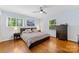 Bright bedroom showcasing hardwood floors, a large window and a dark wood dresser at 3329 Winnipeg Cir, Charlotte, NC 28210