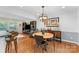Cozy dining area with hardwood floors features a modern chandelier, round table, and stylish sideboard at 3329 Winnipeg Cir, Charlotte, NC 28210